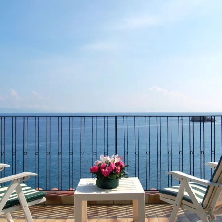 Sea-view terrace with a table and chairs on the Sicilian coast